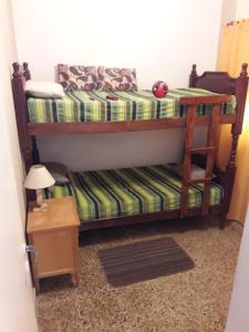 een slaapkamer met twee stapelbedden en een tafel bij Mary in Costa Azul