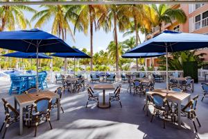 a patio with tables and chairs with blue umbrellas at DoubleTree by Hilton Grand Key Resort in Key West
