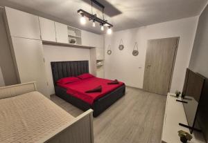 een slaapkamer met een rood bed in een kamer bij AFI Discret Jacuzzi in Boekarest