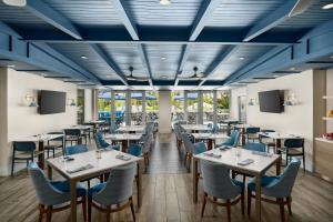 a restaurant with white tables and blue chairs at DoubleTree by Hilton Grand Key Resort in Key West