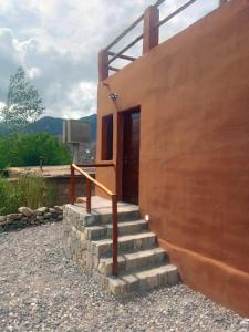 a set of stairs leading to a building with a door at Alojamiento La Oti in Tilcara