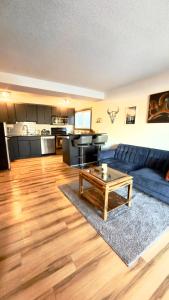 a living room with a blue couch and a table at Cozy boho downtown apartment in Calgary