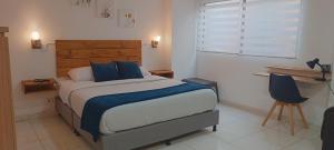 een slaapkamer met een groot bed met blauwe kussens bij ALOJARTE RIONEGRO - Acogedor estudio - ubicación privilegiada in Rionegro