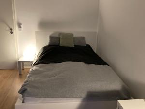 a bed in a white room with two pillows on it at Über den Dächern von Offenbach in Offenbach