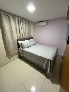 ein kleines Schlafzimmer mit einem Bett und einem Fenster in der Unterkunft Barra prime 1539 in Barra dos Coqueiros