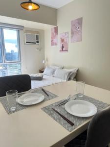 a table with two plates on it with a bed at Modern Studio IT Park Fast Wi-Fi, Pool,Netflix in Sampong