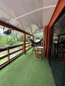 een balkon met een hangmat en een tafel en stoelen bij Cabanas Carijó in Santarém