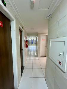 einen Flur in einem Gebäude mit einem Schild an der Wand in der Unterkunft Hotel Ellegance in Salvador