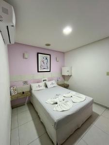 ein Schlafzimmer mit einem großen Bett mit rosa Wänden in der Unterkunft Hotel Ellegance in Salvador + 6 Fotos