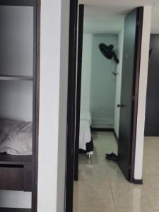 een kamer met een slaapkamer met een bed en een spiegel bij Apartamento Faunaventura cerca Parque del Café con piscina in Montenegro