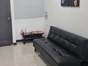 een zwarte leren bank in een woonkamer met een tafel bij Apartamento Faunaventura cerca Parque del Café con piscina in Montenegro