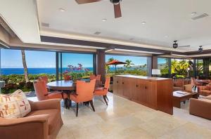 a living room with a table and chairs and the ocean at Luxury Oceanview Villa with Infinity Pool in Hapuna Beach