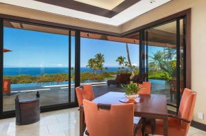 a dining room with a table and a view of the ocean at Luxury Oceanview Villa with Infinity Pool in Hapuna Beach