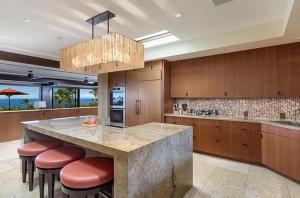 a large kitchen with a large island with bar stools at Luxury Oceanview Villa with Infinity Pool in Hapuna Beach