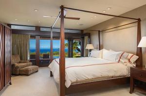 a bedroom with a bed and a balcony with the ocean at Luxury Oceanview Villa with Infinity Pool in Hapuna Beach +8 photos