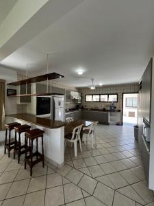 a large kitchen with a table and chairs in it at A casa do sonho in Palhoça