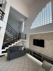 a living room with a couch and a flat screen tv at A casa do sonho in Palhoça