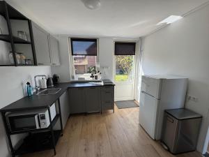 een keuken met een witte koelkast en een spoelbak bij Zola Lodge in Rucphen