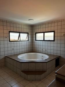 a large tub in a bathroom with two windows at A casa do sonho in Palhoça +20 photos