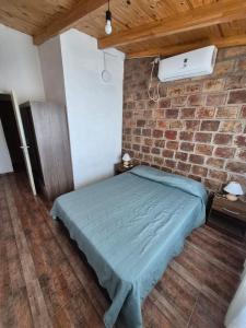 un lit dans une chambre avec un mur de briques dans l'établissement Cabaña La Zarzamora, à La Estancia