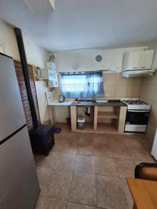 une petite cuisine avec un évier et une cuisinière dans l'établissement Cabaña La Zarzamora, à La Estancia