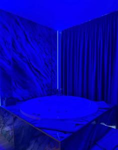 een badkamer met een groot bad met een blauw plafond bij AFI Discret Jacuzzi in Boekarest