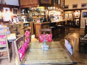 een restaurant met een houten tafel met stoelen en een bar bij Great Malvern Hotel in Great Malvern
