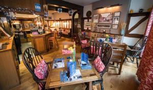 een eetkamer met een tafel, stoelen en een bar bij Great Malvern Hotel in Great Malvern