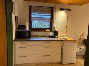 una cucina con bancone, forno a microonde e finestra di Ruhig gelegenes Ferienzimmer in Bodolz a Lindau-Bodolz