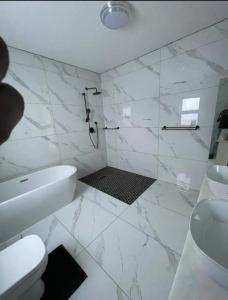 een witte badkamer met douche en toilet bij ProAvia Apartments and Hotel-Long Beach in Walvis Bay +25 foto's