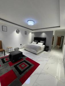 een grote slaapkamer met een bed en een tapijt bij ProAvia Apartments and Hotel-Long Beach in Walvis Bay