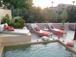 un patio con sofás y una piscina de agua en Riad Viva, en Marrakech