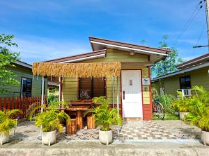 Lapu Lapu CityOlango Island - S&E-1 Tiny Guest House Fully Furnished with Hot Shower, Washer, Wi-Fi, Netflix & King-size Bed的前面有一张桌子的绿色房子
