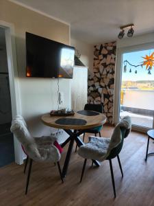 un soggiorno con tavolo, sedie e televisione di Ferienwohnung Alpenblick a Grafenhausen