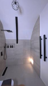 een witte badkamer met een douche en een licht bij Kubotique Beachfront Staycation in El Nido