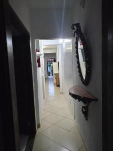 a hallway with a mirror on the wall and a table at Moinho dos ventos in São Pedro da Aldeia