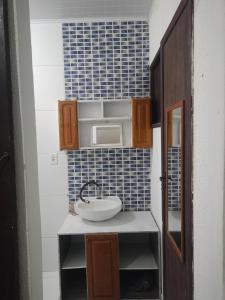 a small kitchen with a sink and a microwave at Moinho dos ventos in São Pedro da Aldeia