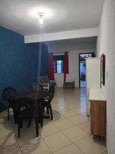a living room with a table and chairs and a refrigerator at Moinho dos ventos in São Pedro da Aldeia