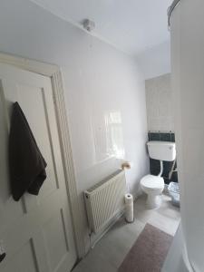 een witte badkamer met een toilet en een raam bij Bayview in Ballysadare +2 foto's