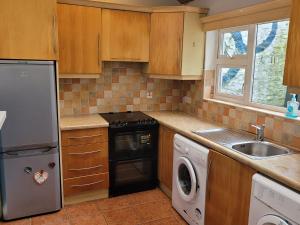 een keuken met een wasmachine, een wastafel en een vaatwasser bij Bayview in Ballysadare