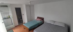 een kleine slaapkamer met een bed en een bank bij Hostal Escondido in La Serena