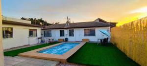 een achtertuin met een zwembad en groen gras bij Hostal Escondido in La Serena