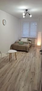 una camera da letto con un letto e un pavimento in legno di Mieszkanie 3 Pokoje Self Check In a Szprotawa Altre 14 foto