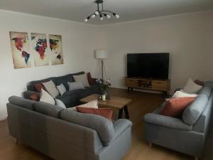 a living room with two couches and a flat screen tv at Ferienhaus am Seeburgersee 100 Meter zum Wasser in Niederdorla