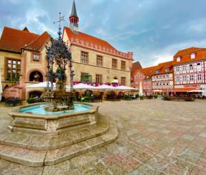 a fountain in the middle of a courtyard with buildings at Ferienhaus am Seeburgersee 100 Meter zum Wasser in Niederdorla