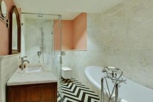 a bathroom with a tub and a sink and a bath tub at The Fern Bambora Fort Udaipur, Bambora, Series by Marriott in Udaipur +8 photos