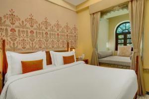 a bedroom with a large white bed and a window at The Fern Bambora Fort Udaipur, Bambora, Series by Marriott in Udaipur