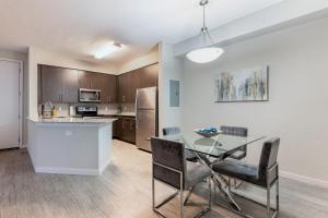 a kitchen and dining room with a glass table and chairs at Spacious 3BR | Pool, Gym, Near Beach & Speedway in Daytona Beach