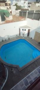 een groot blauw zwembad bovenop een gebouw bij Departamento en Playa Pulpos - 2 habitaciones - Piscina compartida in Arica