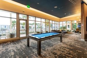 a pool table in a room with windows at Spacious 3BR | Pool, Gym, Near Beach & Speedway in Daytona Beach